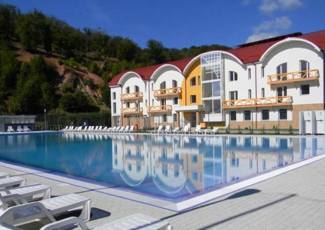 a hotel with a swimming pool in front of a building at Oras Zlatna in Zlatna