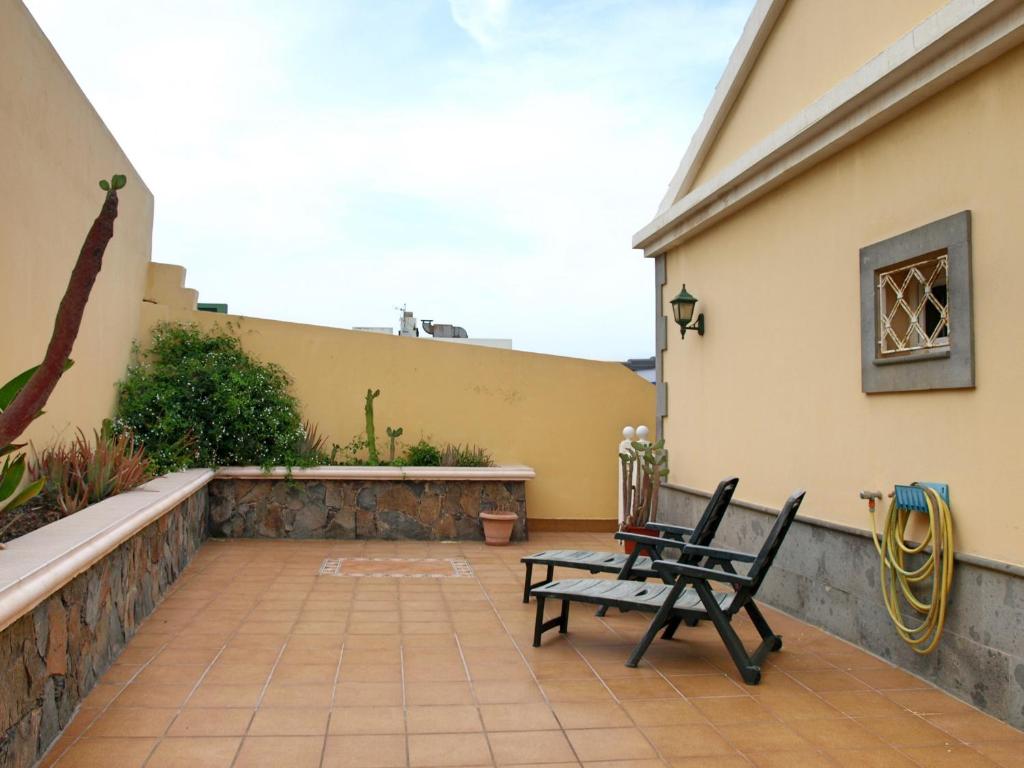 eine Terrasse mit 2 Stühlen und einer Bank in der Unterkunft Flatguest - Spacious Home in La Garita