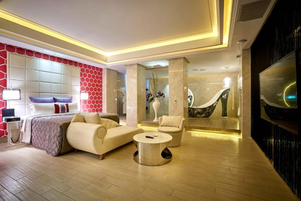 台北的住宿－紫虹汽車旅館，一间卧室配有一张床、一张沙发和一张桌子