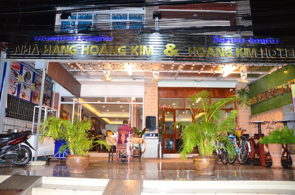 een man in een stoel voor een winkel bij Hoang Kim Hotel in Vientiane