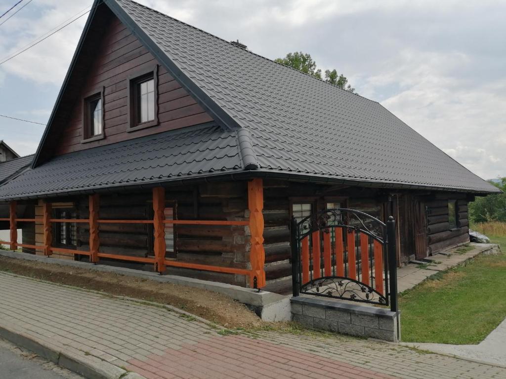 a large wooden cabin with a black roof at ChatkaDuraje in Jaworzynka