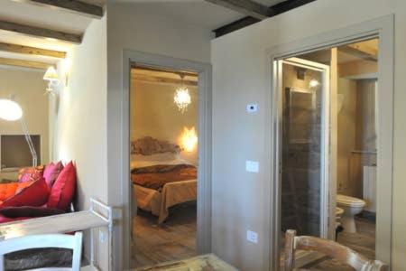 - une chambre avec un lit et un miroir dans l'établissement appartamento di classe nel castello di Panicale, à Panicale