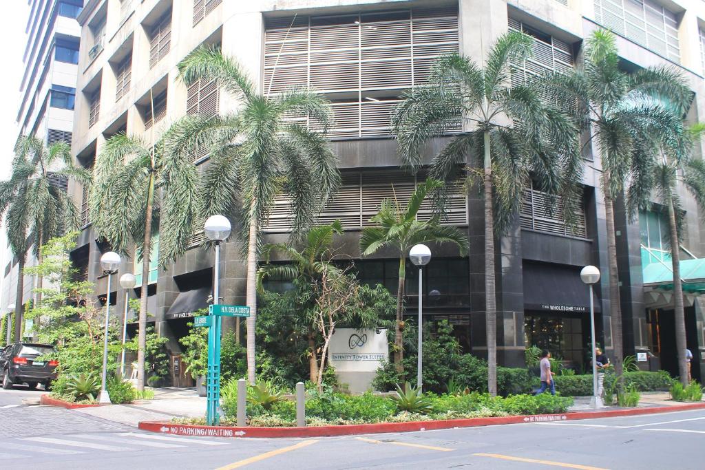 a palm tree lined street in front of a building at Infinity Tower Suites in Manila
