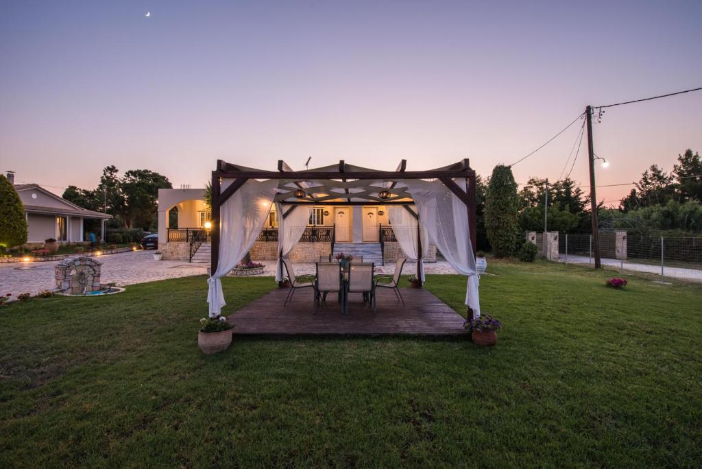 a gazebo with a table and chairs in a yard at Mystic Garden Apartments in Zakynthos Town
