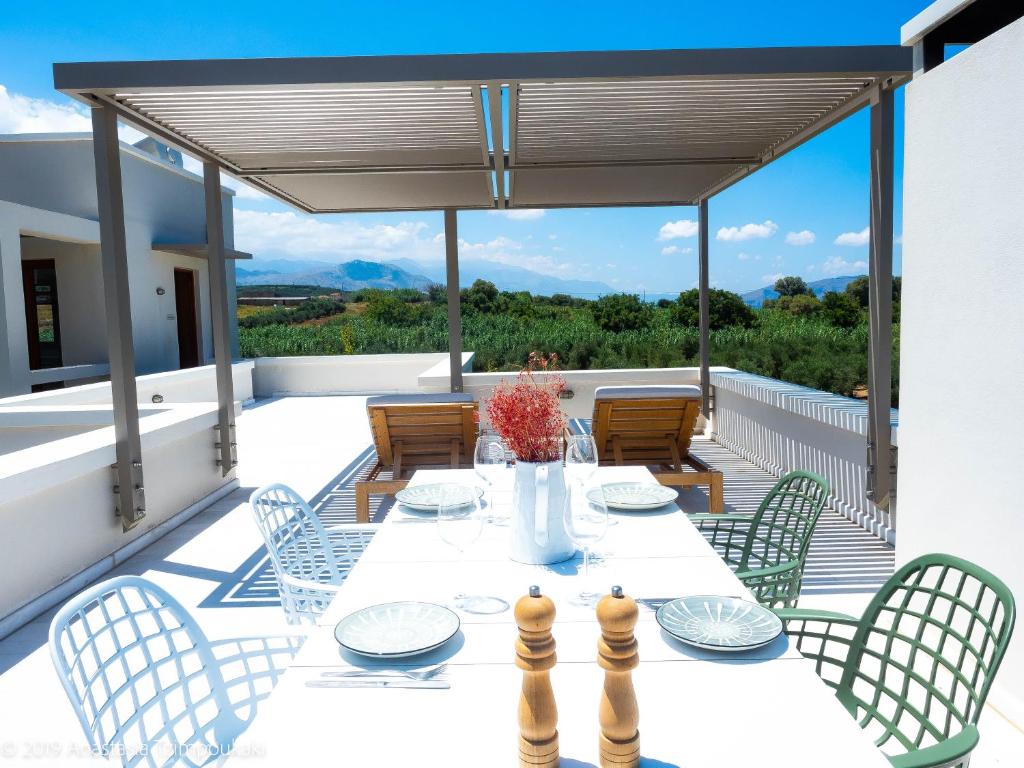 a patio with a table and chairs on a deck at Mikro Livadi Special Lodges - Has an Eco Salt water pool - 150m from the beach in Episkopi