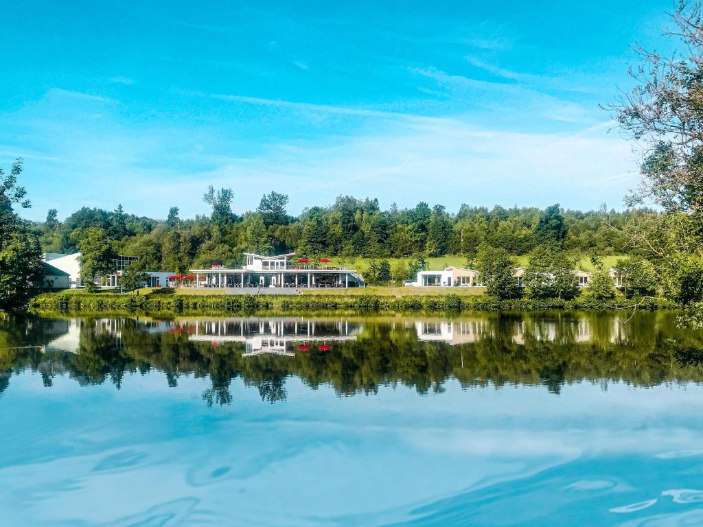 uma vista para um lago com casas ao fundo em MotelplusHotel BiggeSeeFront em Olpe