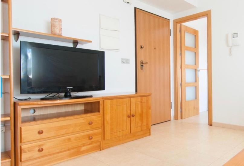 a flat screen tv sitting on top of a wooden entertainment center at Apartamento zona residencial el palmar in El Palmar