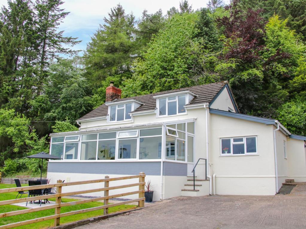 a white house with a fence in front of it at Caesamson in Caersws