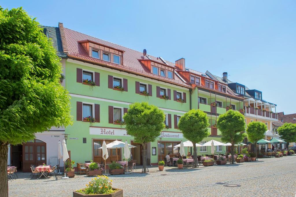 ein großes, grünes Gebäude auf einer Straße mit Bäumen in der Unterkunft Hotel Wilder Mann in Königstein in der Oberpfalz
