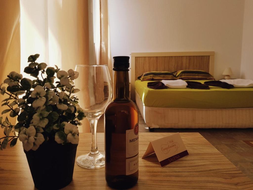 una bottiglia di vino seduta su un tavolo con un bicchiere di Guest Apartments Salena a Sunny Beach