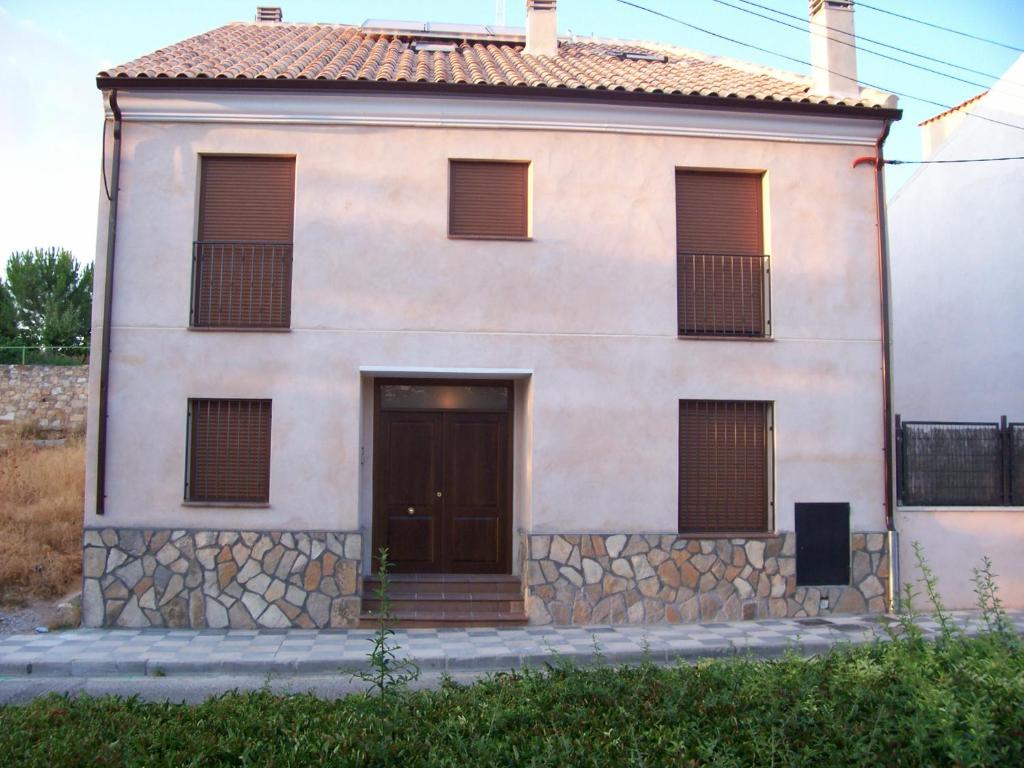 Casa blanca grande con puerta y ventanas en Apartamentos Rurales Romero, en Nohales