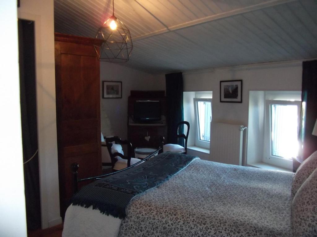 a bedroom with a bed and a living room at les mésanges in La Grève-sur-Mignon