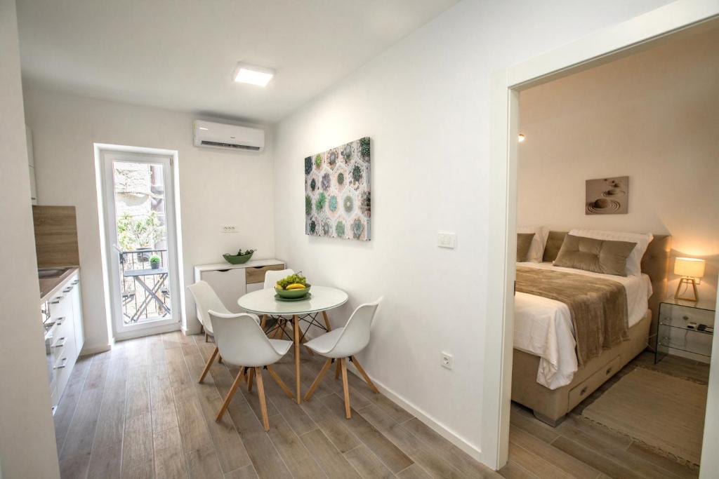 um quarto com uma cama, uma mesa e cadeiras em Apartment Dioclessima em Split