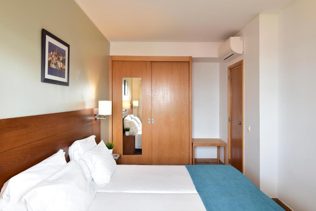 a bedroom with a bed with a wooden headboard at Aqualuz Lagos by The Editory in Lagos