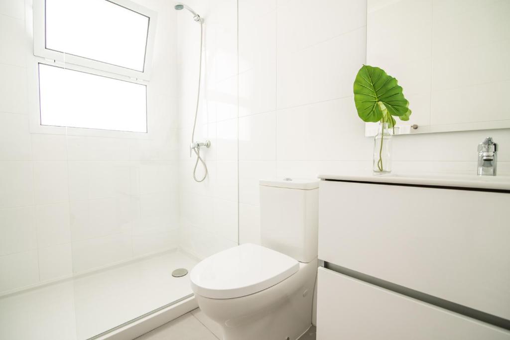 a white bathroom with a toilet and a window at Casa do Outeiro with Heated Pool 30C in Povoação