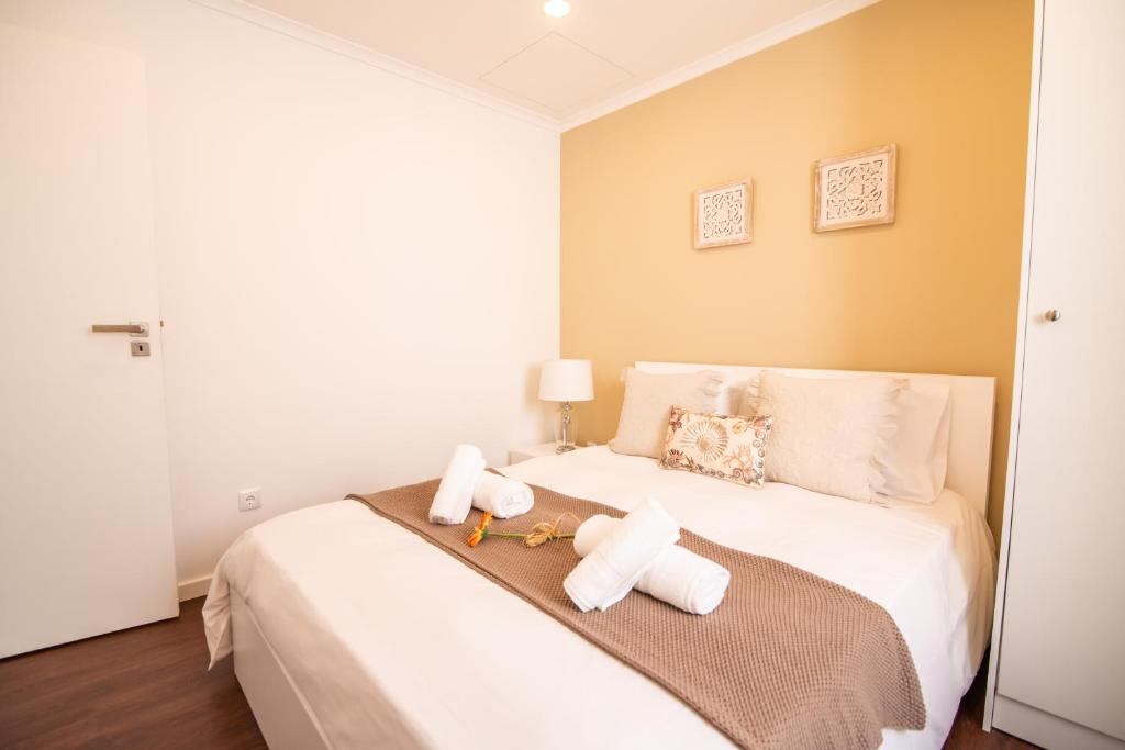 a bedroom with a white bed with towels on it at Casa do Outeiro with Heated Pool 30C in Povoação