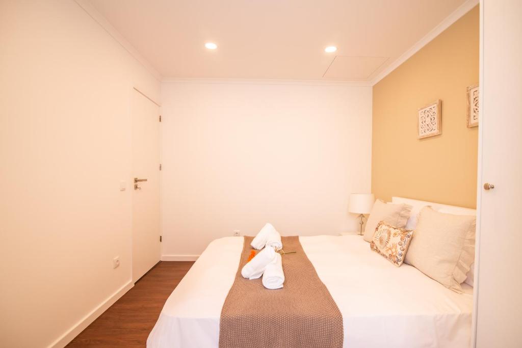 a bedroom with a large bed with white sheets at Casa do Outeiro with Heated Pool 30C in Povoação