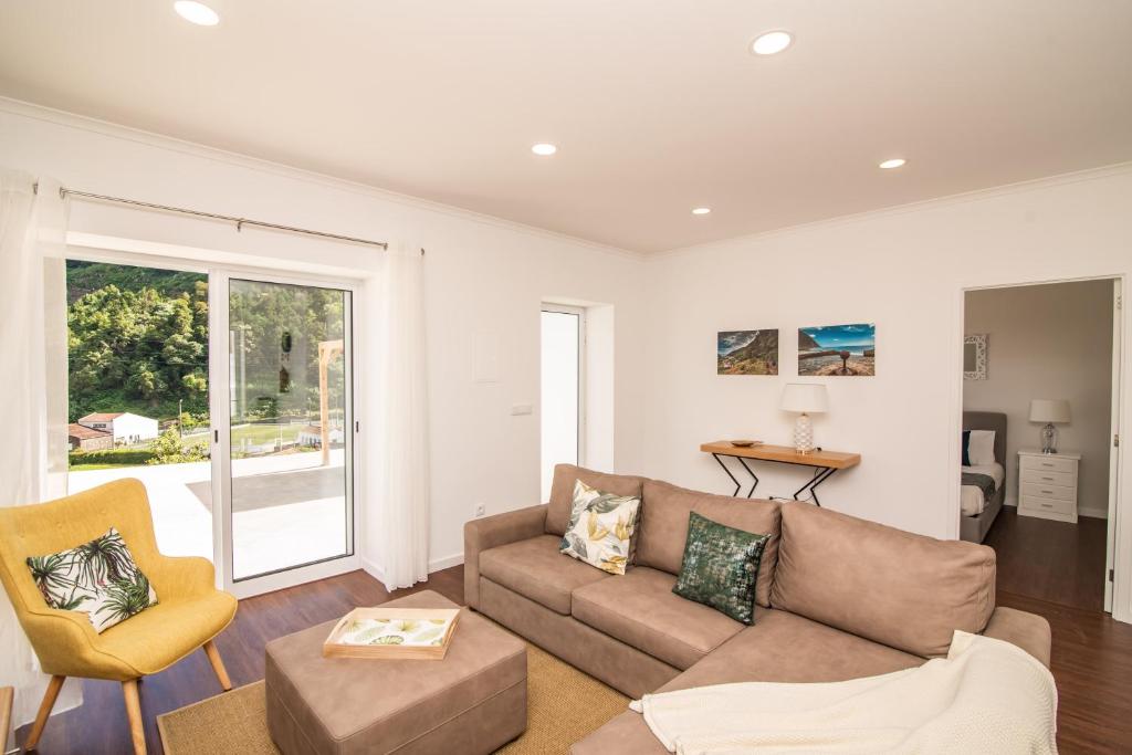 a living room with a couch and a chair at Casa do Outeiro with Heated Pool 30C in Povoação