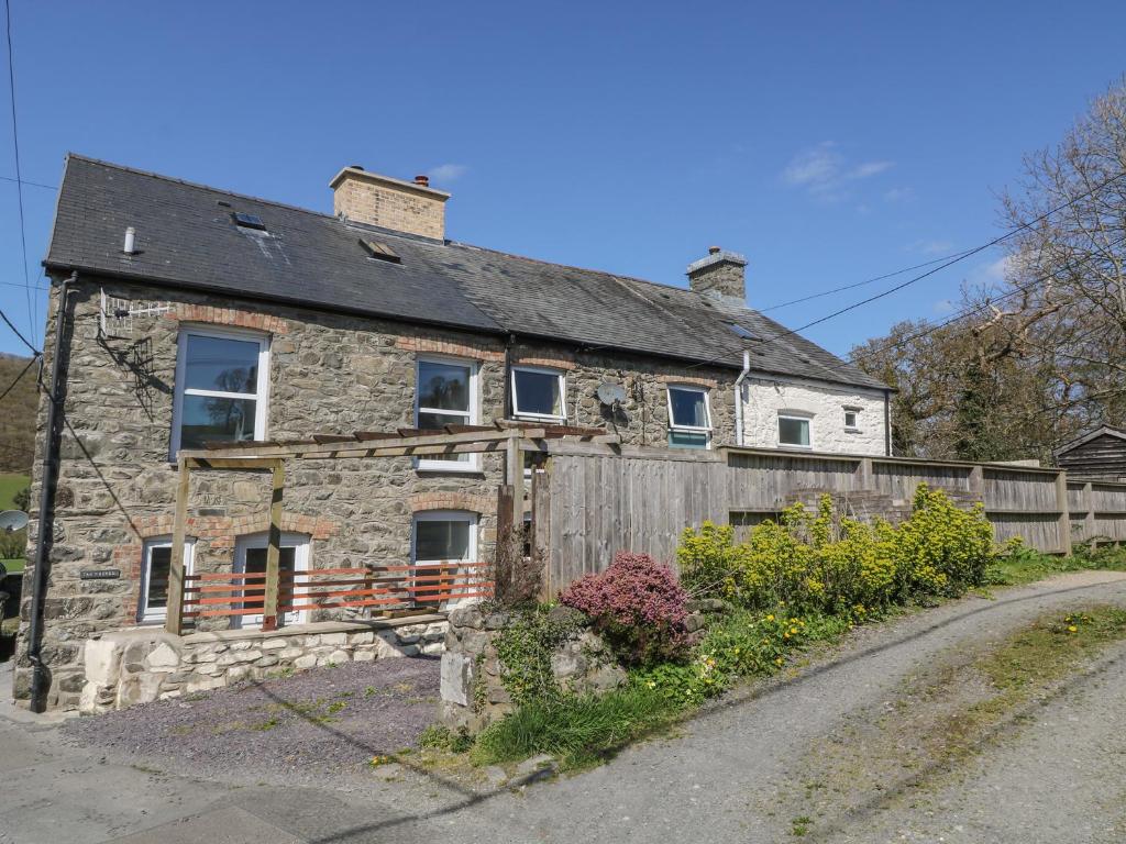 an old stone house on the side of a road at 1 Tan Y Gerddi in Machynlleth