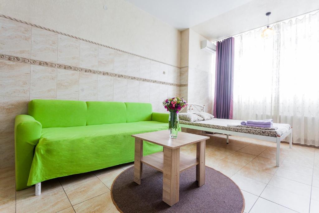 un sofá verde en una sala de estar con mesa en Dream Apartments, en Kiev