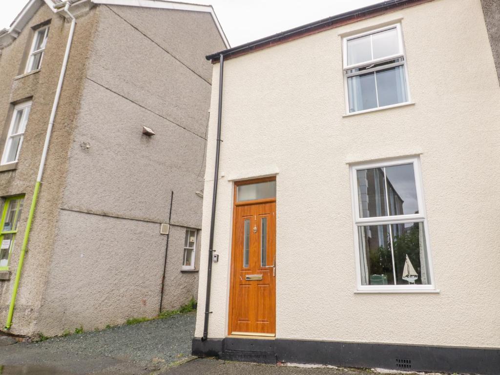 a white brick house with a wooden door at 1 Castle Row in Beaumaris