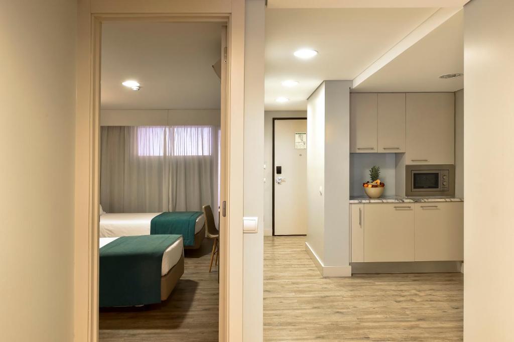 a hotel room with a bed and a kitchen at Aqualuz Lagos by The Editory in Lagos