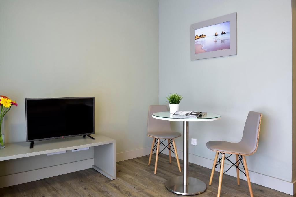 a living room with a tv and a table and chairs at Aqualuz Lagos by The Editory in Lagos