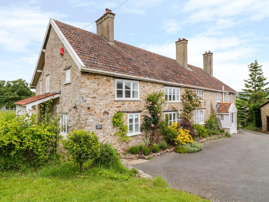 una antigua casa de piedra con entrada en Whitehall Farm Cottage en Honiton