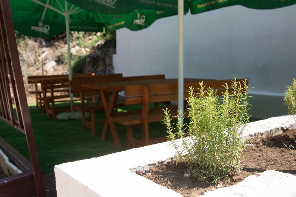 a wooden table and chairs under an umbrella at Trsteno Beach Apartments in Budva
