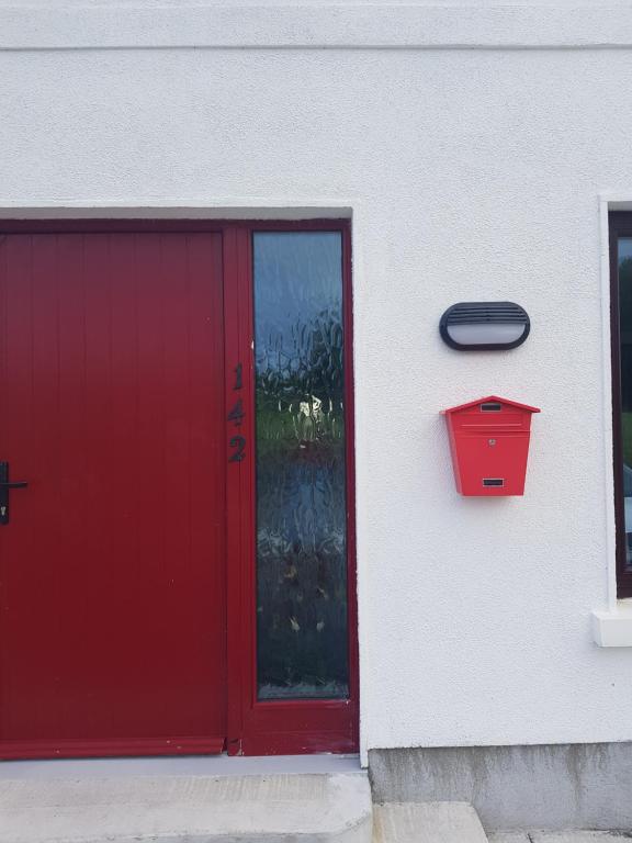 a red door and a red mailbox on a building at Park View in Galway