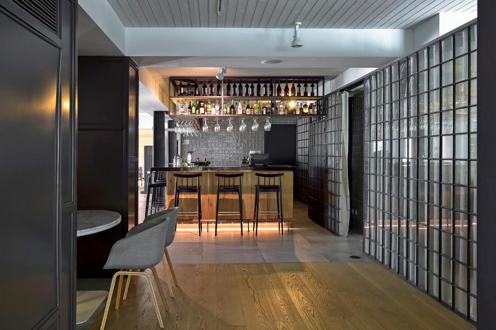 a bar with a table and chairs in a room at Aqualuz Lagos by The Editory in Lagos