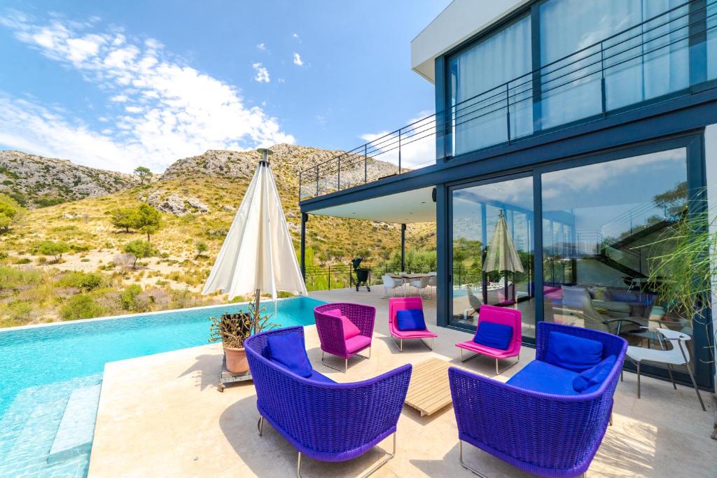 ein Haus mit lila Stühlen und einem Pool in der Unterkunft Nature Villa in Alcúdia