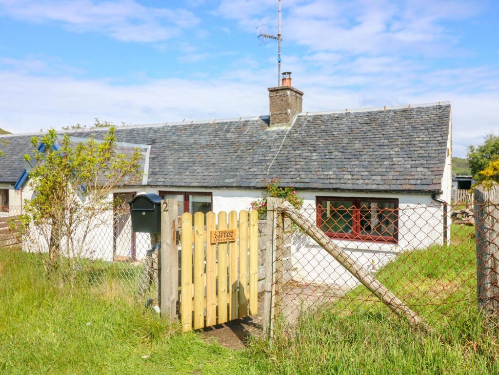 a white house with a fence in front of it at 2 Tougal in Mallaig