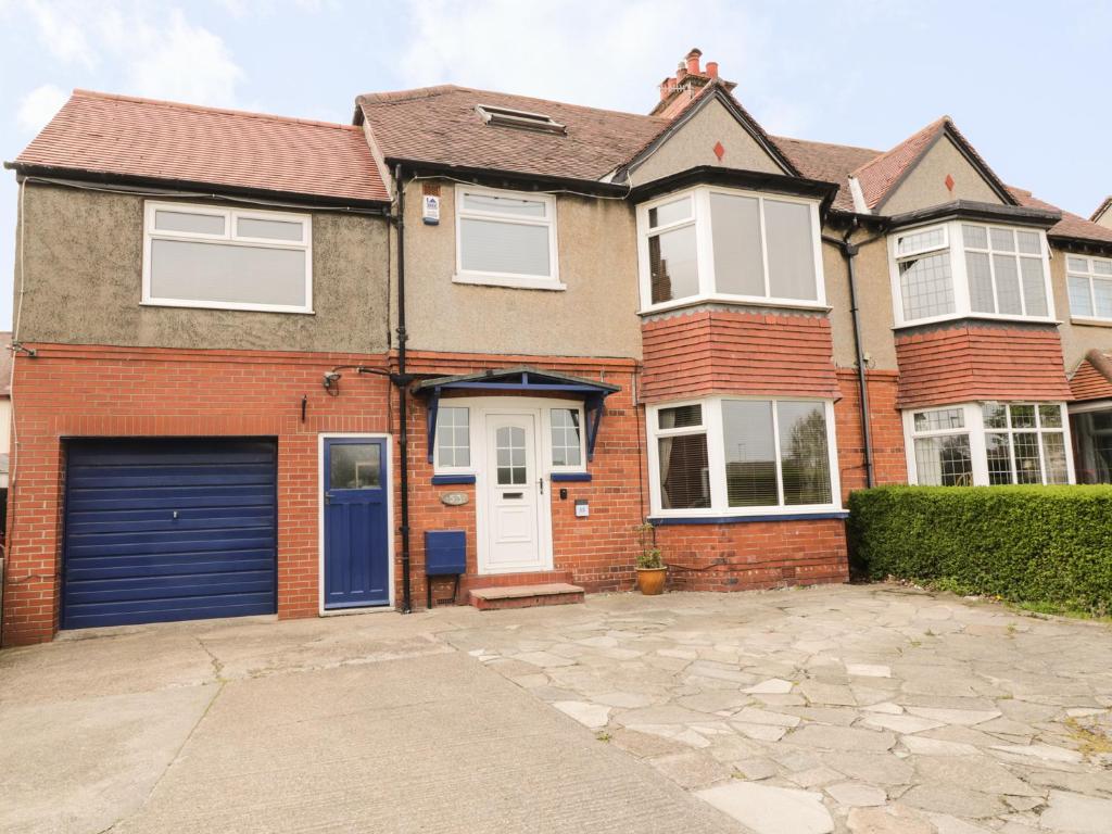 a brick house with a blue garage at 53 Burniston Road in Scarborough