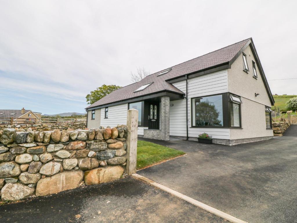 una cerca de piedra frente a una casa en Llwyd Coed Canol, en Caernarfon