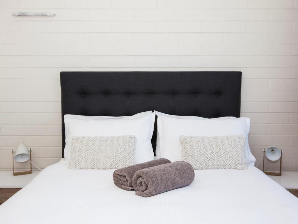 a white bed with a towel on top of it at Pelican Sands Scamander in Scamander