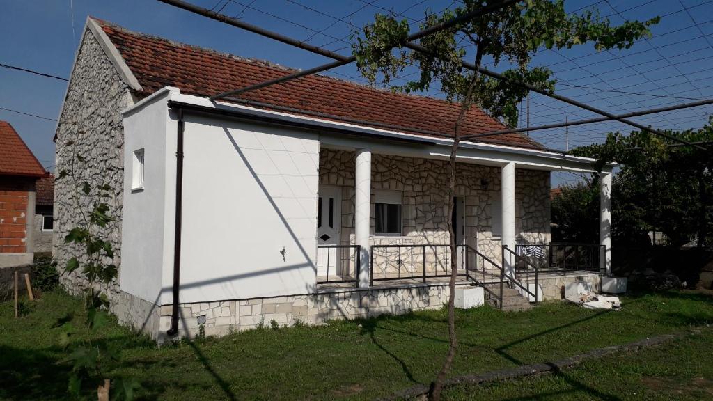 ein weißes Haus mit rotem Dach in der Unterkunft Kamena Kuca Family Rodin in Čapljina