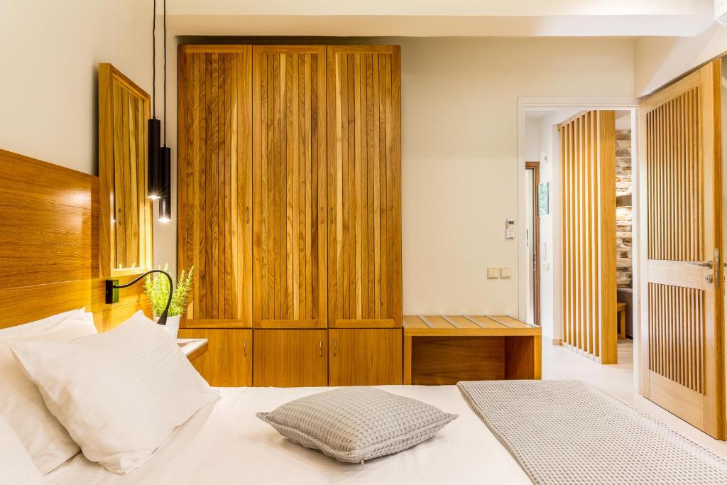 a bedroom with a bed and a wooden cabinet at Skopelos Holidays Hotel & Spa in Skopelos Town