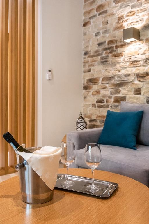 two wine glasses on a table with a couch at Skopelos Holidays Hotel & Spa in Skopelos Town