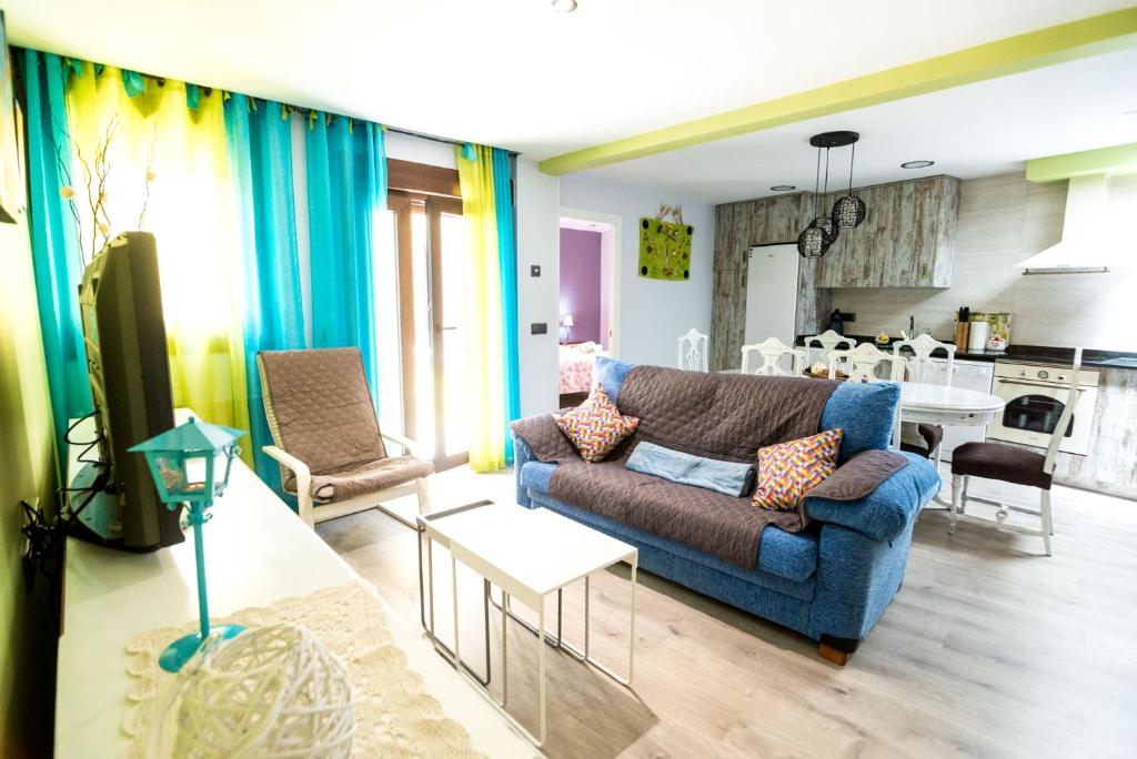 sala de estar con sofá azul y cocina en Apartamento Las Suertes, en Cantavieja