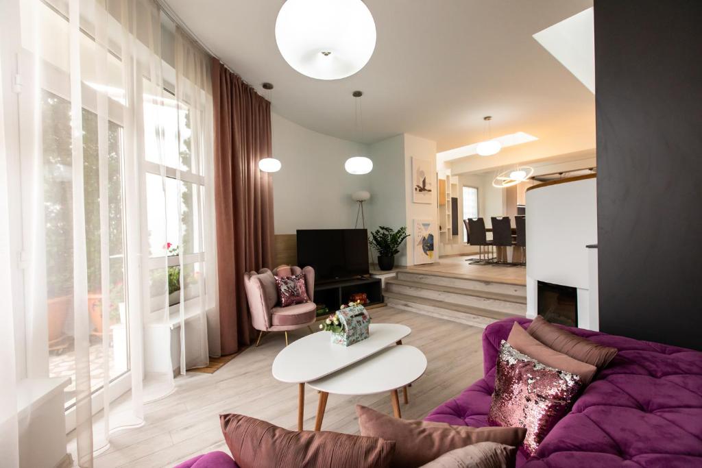 a living room with a purple couch and a table at Casa Bella WHC in Cluj-Napoca