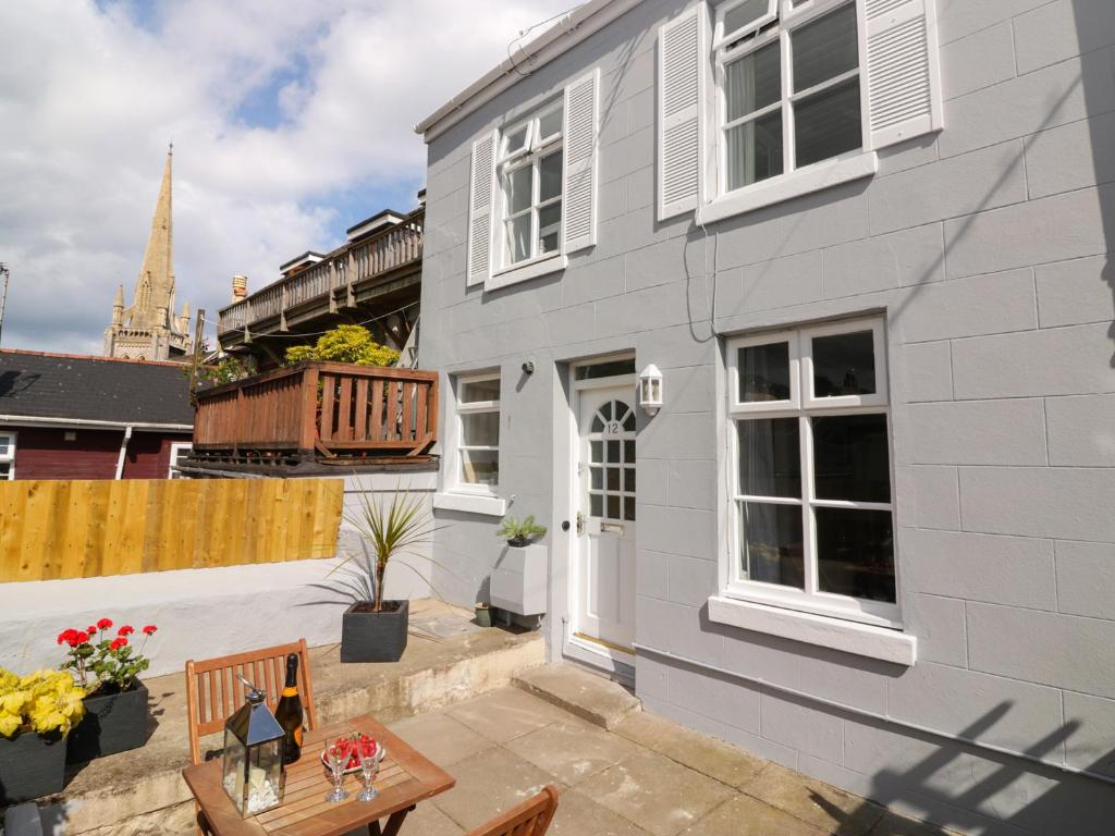 a patio with a table and a house at Harbourside Cottage in Torquay