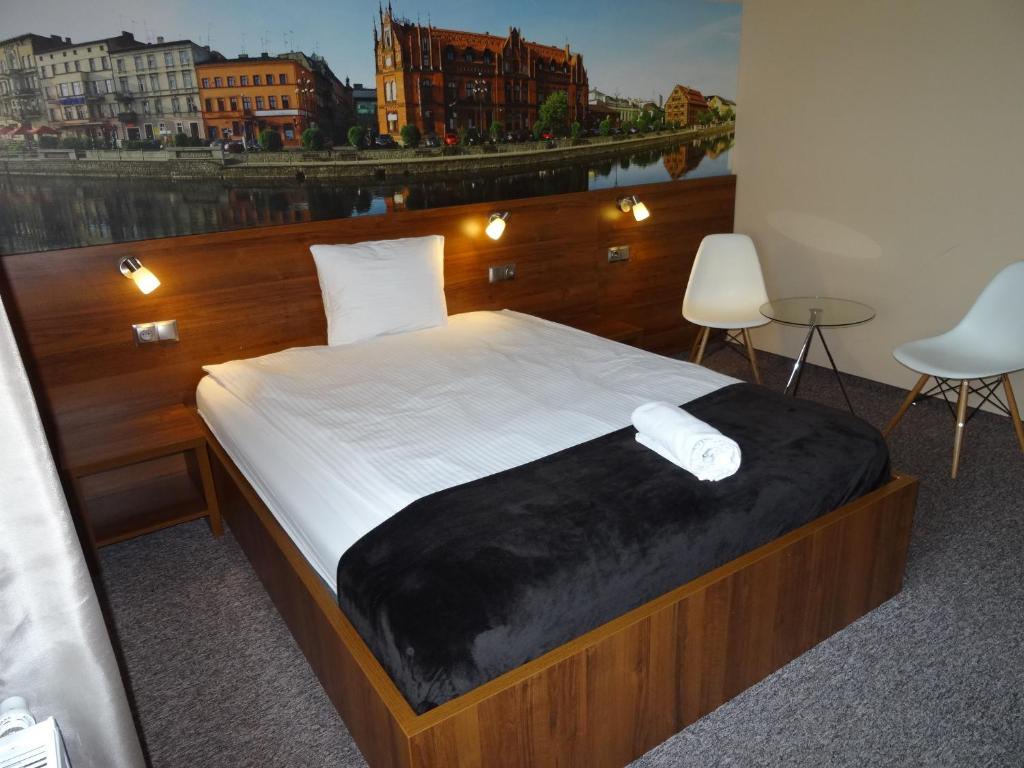 ein Schlafzimmer mit einem großen Bett und einem großen Fenster in der Unterkunft Pro B&B in Osielsko