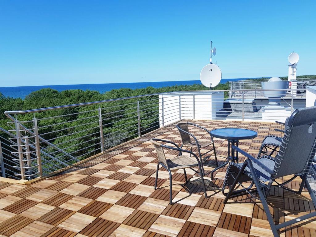 a patio with chairs and a table on a deck at Apartament Piasek i Morze in Rowy