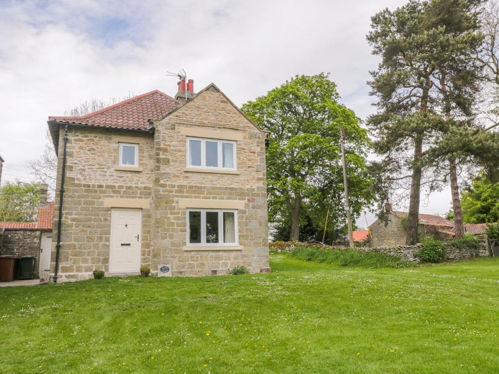 a brick house with a lawn in front of it at Manor Cottage in Pickering