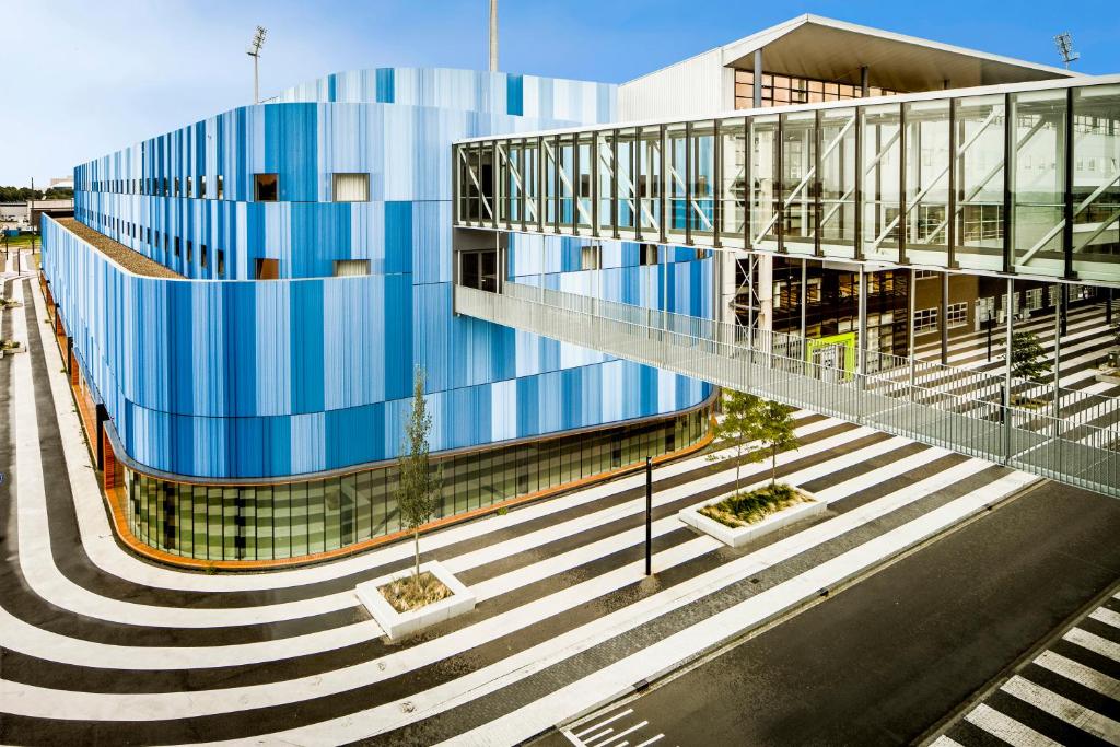 ein blaues Gebäude mit einer Treppe davor in der Unterkunft Fletcher Wellness-Hotel Sittard in Sittard