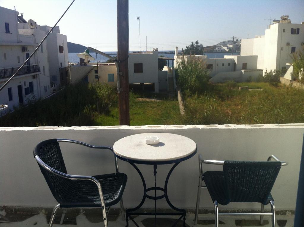 un tavolo e 2 sedie su un balcone con una tazza di caffè di Gorgona Studios a Livadi