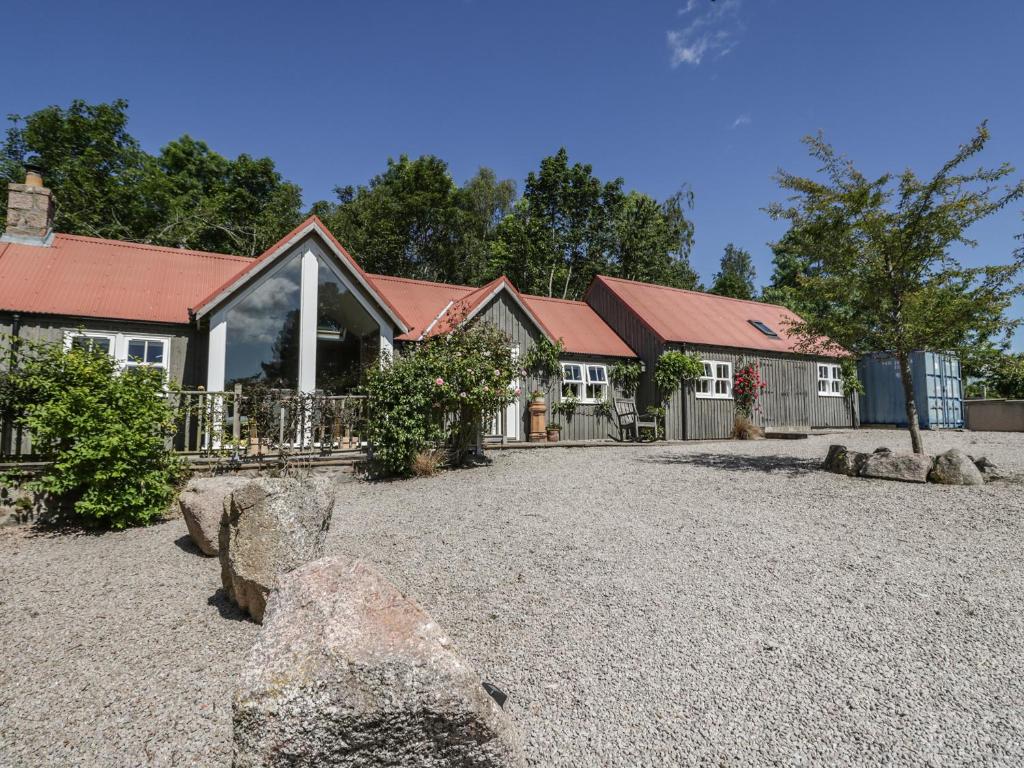 een huis met rotsen ervoor bij Drumhead Bothy in Banchory