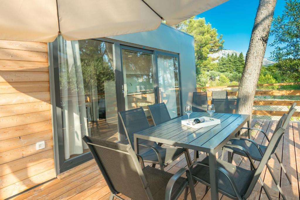 a table and chairs on the deck of a house at Apartments and Mobile Homes Makarska in Makarska