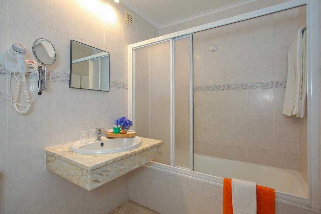 a bathroom with a sink and a shower at Aparthotel Barracuda in Ponta Delgada